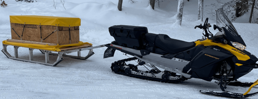 Snowmobile pulling a fishing gear trailer
