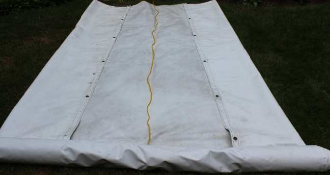 Roll up the tarp in a straight line keeping the rope centered